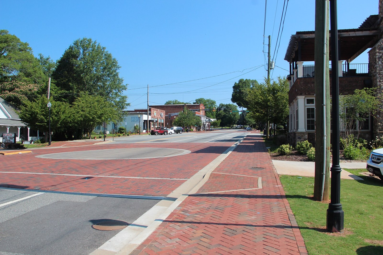 Brick-paved streets and sidewalks along Main Street in downtown Kennesaw, with historic storefronts in the distance.